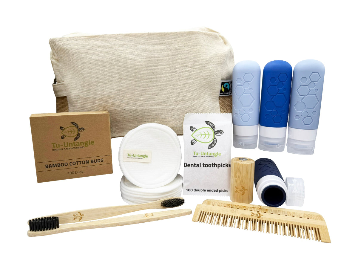 Collection of eco-friendly products including a canvas bag, bamboo toothbrush, and cleaning items on a white background.